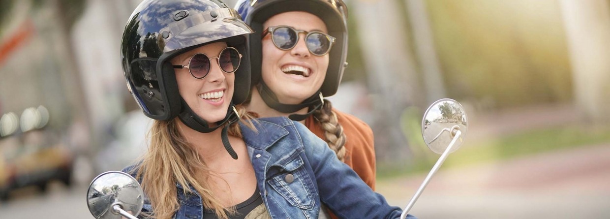 Twee jonge vrouwen rijden samen op een scooter